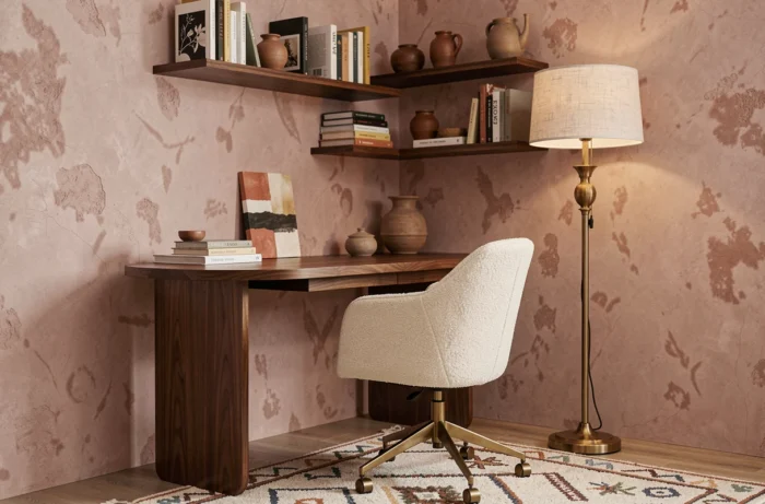 Bureau à domicile mi-siècle moderne avec chaise en bouclé, étagères décorées de céramiques et mur en enduit à la chaux rose